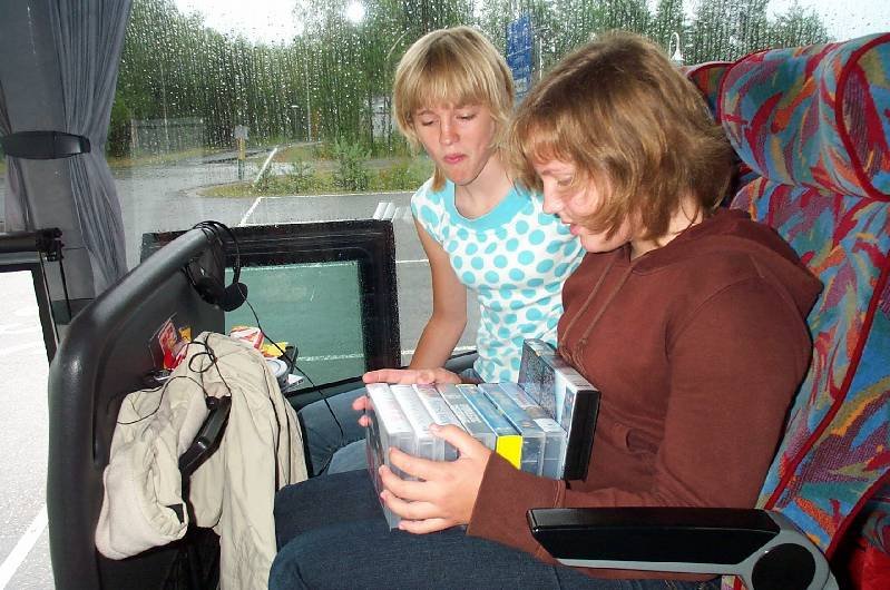 Åsa och Stina väljer film för att fördriva bussresan.